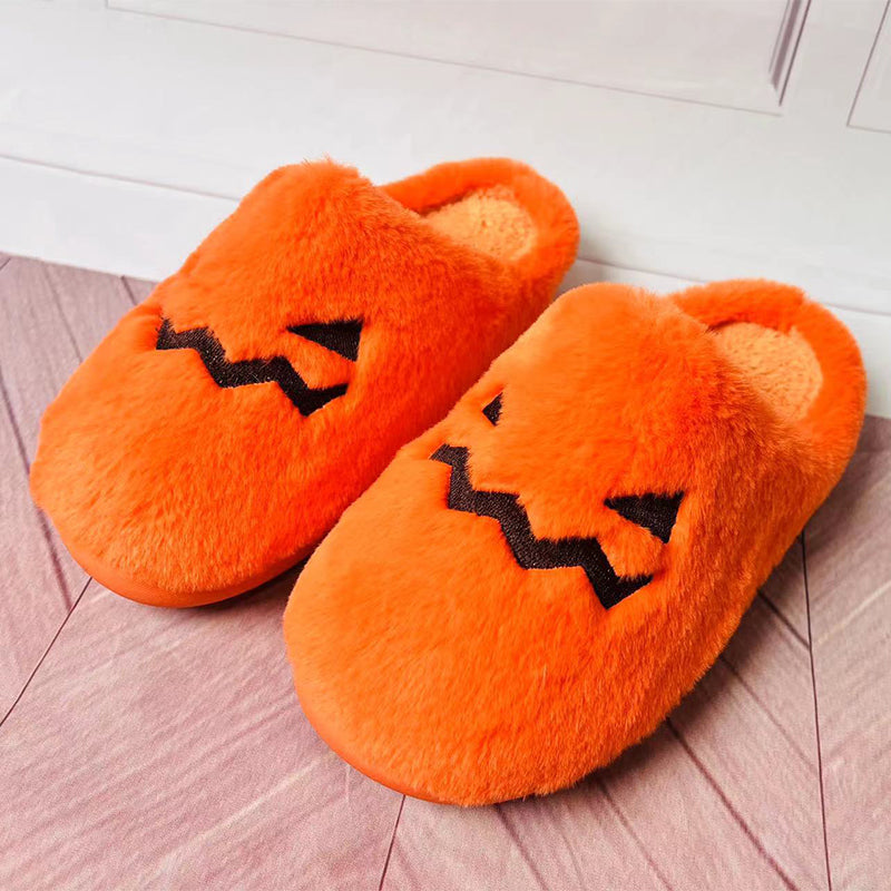 Cute pumpkin slippers for winter featuring plush orange material and playful jack-o'-lantern design.